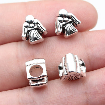 antique silver angel large hole bead shown on fingertips for scale