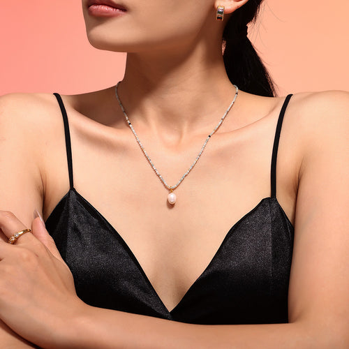 Natural stone bead necklace with pearl pendant on collarbone