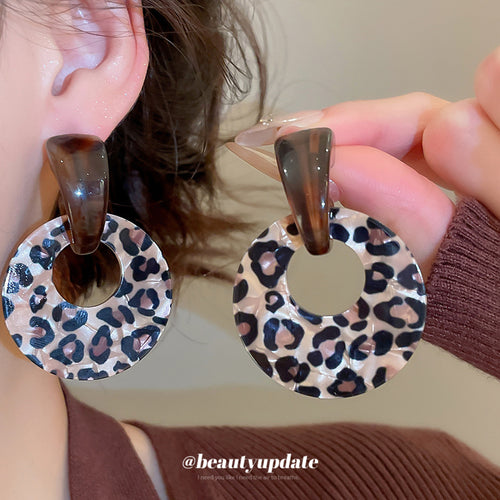 Chunky open resin hoops with two distinct brown leopard patterns shown in a front product view