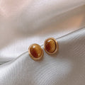 Amber Oval Stud Earrings in Smooth Gold Tone Frames view 2