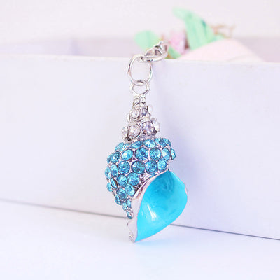 Close-up of a blue conch shell charm with blue and clear rhinestones.