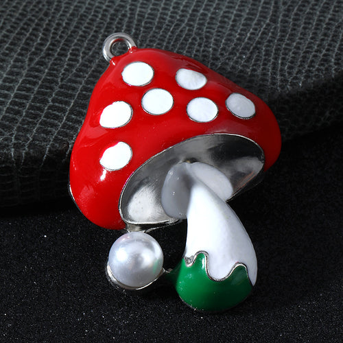 Close-up red mushroom charm with white spots, a silver-tone stem and a faux pearl bead