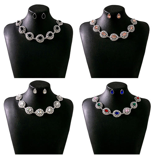 Four teardrop crystal necklace earring sets on black busts white black champagne multicolor