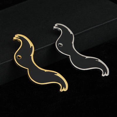 Gold-tone and silver-tone enamel mustache charms shown side by side