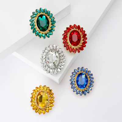 Front view of the oval crystal halo brooch showing an oval faceted center stone surrounded by marquise crystals