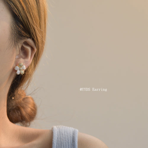White pave flower stud worn on ear side profile
