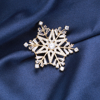 Front view of gold snowflake brooch with clear baguette crystals