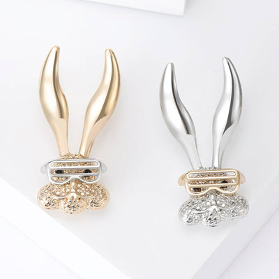 Front view of stylized long-eared rabbit above rectangular crystal-set glasses