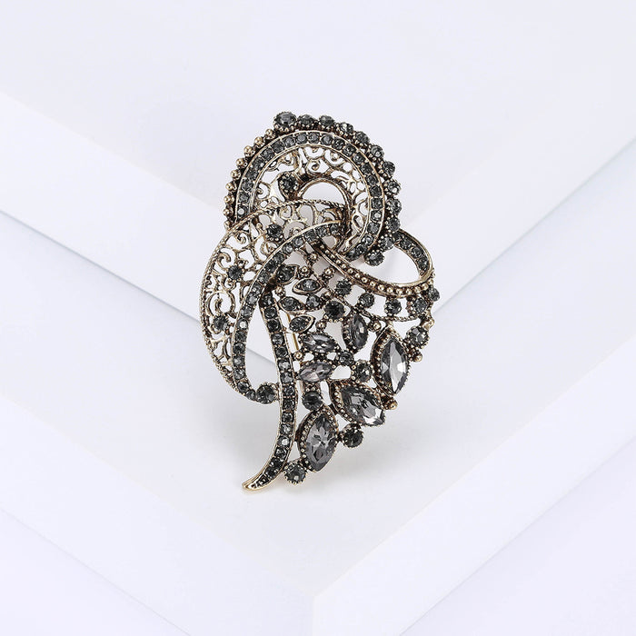Gray Crystal Feather Brooch with Polished Metal and Decorative Accents