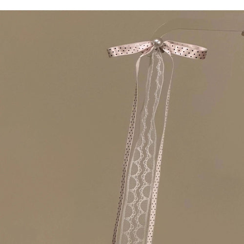 Pink polka dot lace ribbon bow hair clip hanging on clear stand