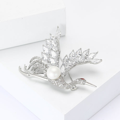 Flying crane brooch three-quarter view on white display