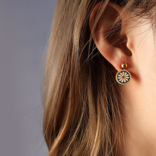 Gold navy daisy enamel drop earring worn on ear