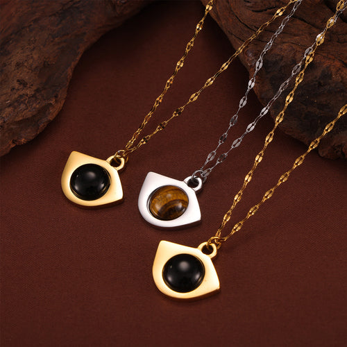 Three eye pendants with black and tiger-eye centers on gold and steel chains