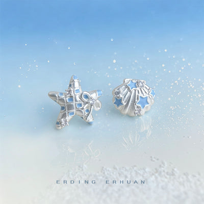 Silver starfish and shell blue enamel studs on blue sand backdrop