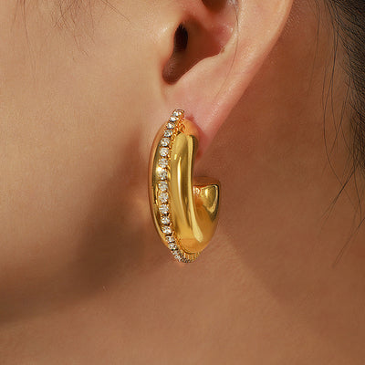 Gold thick C-shape crystal-rim earring worn on model ear close-up