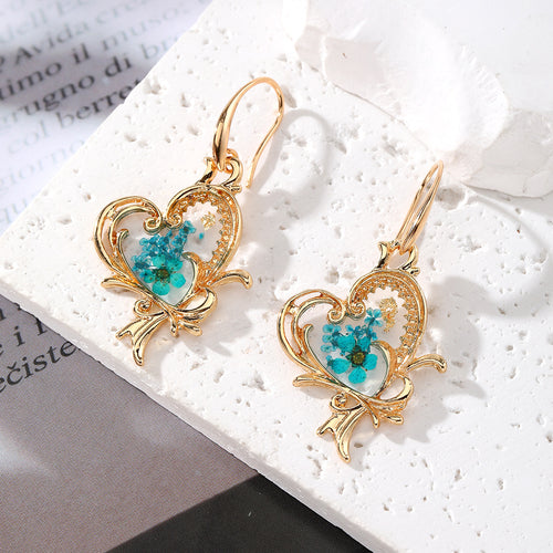 Close-up showing the colors and surface details of gold Tone Heart Butterfly Pressed Flower Resin Hook Earrings