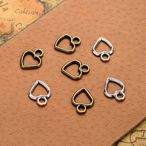 Main product image of the open heart outline charm showing a small open heart outline with a rounded top loop
