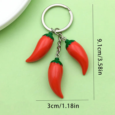 Three red pepper ornaments hang from a round key ring beside printed measurements.