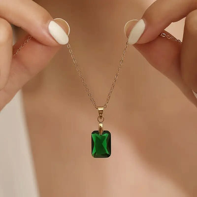 Hands holding gold green emerald-cut rectangle pendant necklace