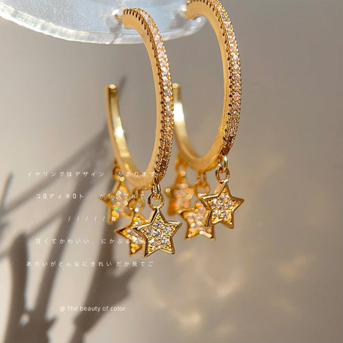 Gold crystal hoop with hanging star charms close-up