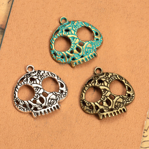 Main product image of the floral skull pendant showing a rounded skull silhouette filled with floral openwork