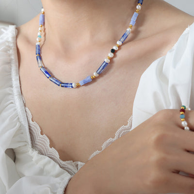 Blue chalcedony tube and pearl necklace worn with white ruffle lace top