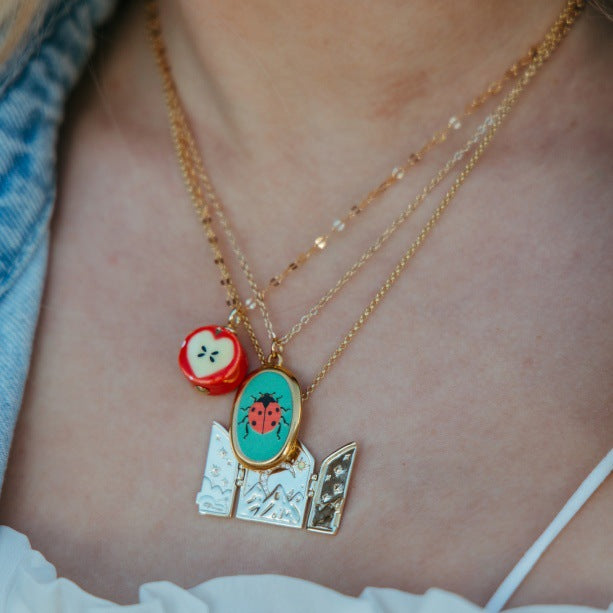 Apple Slice And Ladybug Pendant Necklaces In Gold Tone Metal