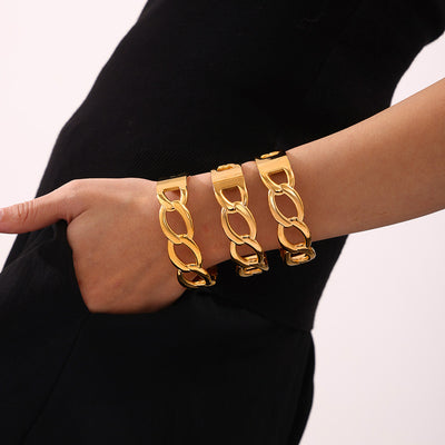 Three gold interlocking chain link bangles stacked on wrist
