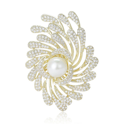 Front view of swirling crystal feather pearl brooch against a white background.