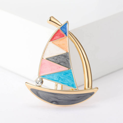 Close-up product view showing the colors and surface details of the enamel sailboat brooch