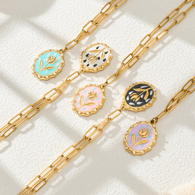 Five gold paperclip tulip enamel oval pendant necklaces on white tile