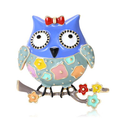 Front view of bright owl perched on a flowered branch with a small red bow