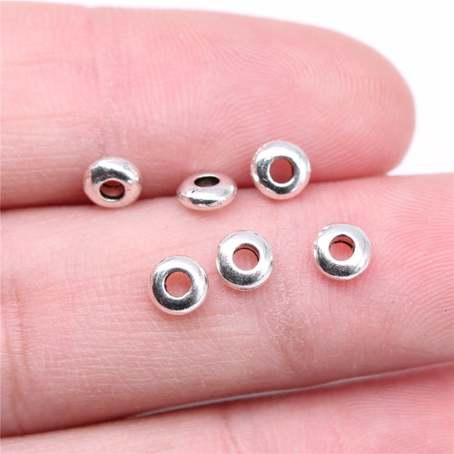 Close-up of plain ring spacer beads showing smooth rounded rings with central threading holes