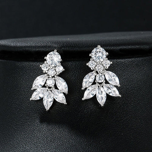 White gold marquise leaf clear stone stud earrings on black surface
