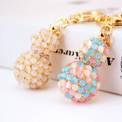 Two gourd-shaped keychains shown in white and mixed pink, blue, and white colors.