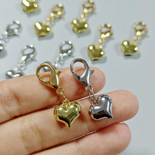 Close-up showing the colors and surface details of puffy Heart Lobster-Clasp Charms in Gold and Silver Tone