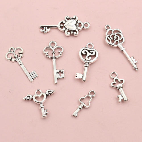Assorted vintage key charms in an antique silver tone shown in a closer grouped view