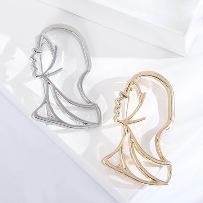 Gold and silver openwork lady silhouette brooches together on white