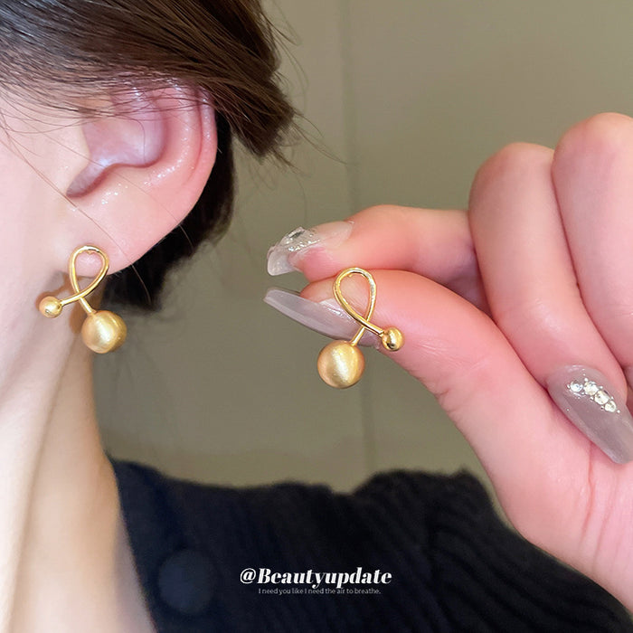 Gold Tone Polished Orb Stud Earrings with Crossing Loops