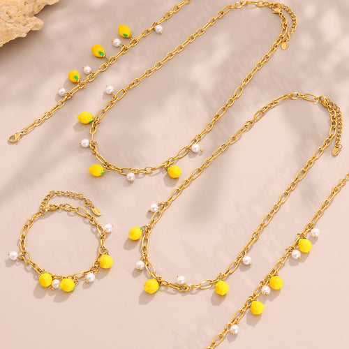 Gold lemon resin necklace bracelet and anklet flat lay on beige