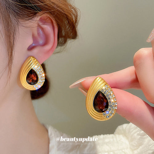 gold tone red teardrop necklace and stud earrings with polished metal accents shown in main image 2 with visible color a