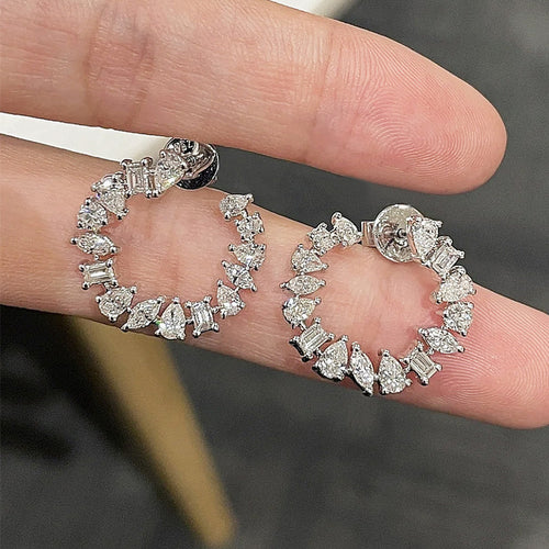 White gold open circle studs showing butterfly backs on fingertips