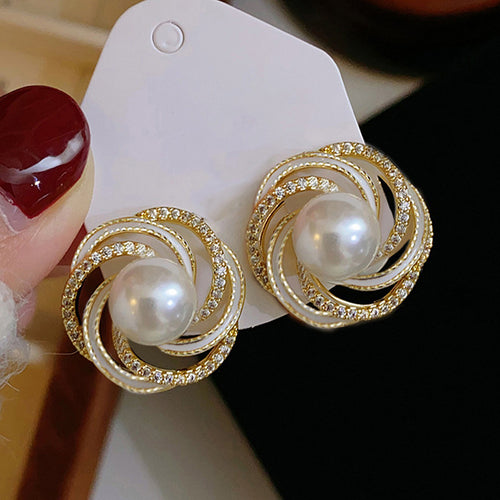 White pearl swirl studs on white card with red nail polish