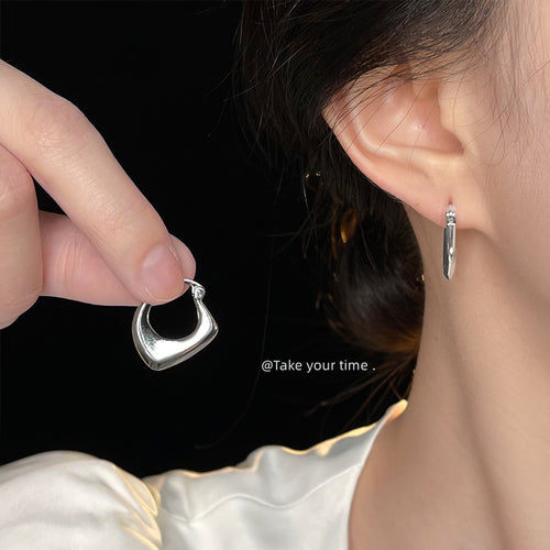 Huggie worn on ear with matching hoop held in hand
