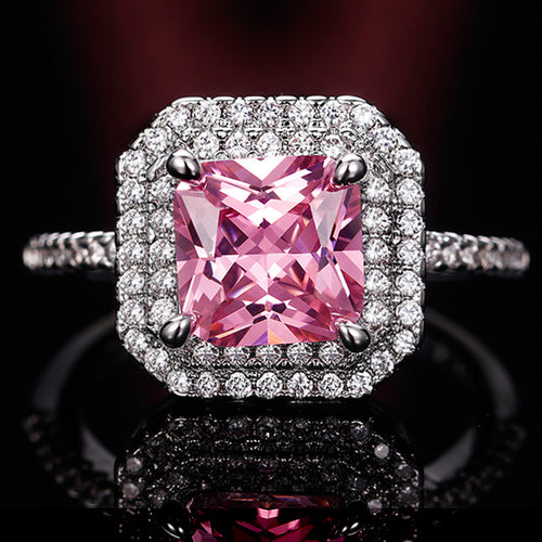 Front view showing a pink square center, clear halo, and stone-set band