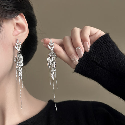 Styled wear view of 银色叶片流苏耳夹 showing silver-tone leaf clusters with slim metal drops and long fine chain fringe