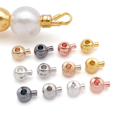 Metallic crimp bead jewelry findings arranged on a light background