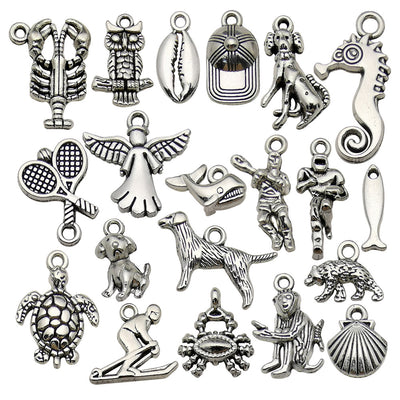 Antique silver crab and dog charms arranged on a light background