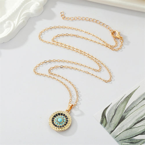 Round gold evil eye pendant full cable chain with lobster clasp on white surface