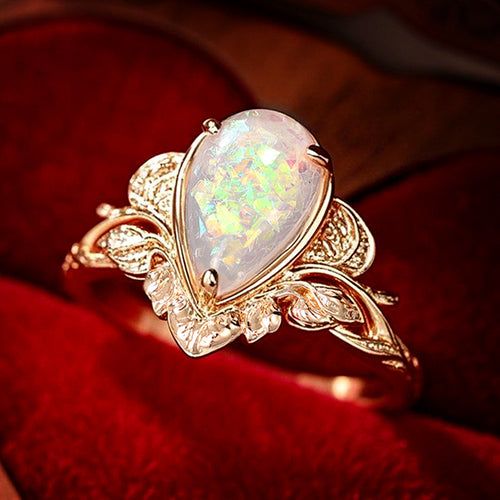Close-up of leaf base teardrop opal ring on red velvet